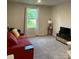 Cozy living room with a red sofa, TV, and a window letting in natural light at 323 J C Dellinger Rd, Cherryville, NC 28021