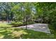 Spacious backyard with mature trees, basketball court, and trampoline at 3429 Lazy Day Ln, Charlotte, NC 28269