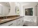 A bathroom with granite countertops, dual sinks, and a soaking tub by the window at 3429 Lazy Day Ln, Charlotte, NC 28269