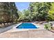 Beautiful in-ground pool surrounded by mature trees and lounge chairs for relaxing poolside at 3429 Lazy Day Ln, Charlotte, NC 28269