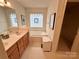 Bright bathroom featuring a vanity with sink, a bathtub with jacuzzi, and stained glass window at 35 Wittenburg Springs Dr, Taylorsville, NC 28681