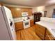 Well-lit kitchen featuring oak cabinets, white appliances, and hardwood floors at 35 Wittenburg Springs Dr, Taylorsville, NC 28681