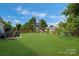 Expansive green backyard with mature trees, a patio, and ample space for activities at 4797 Chesney Nw St, Concord, NC 28027