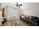 Bright living room featuring neutral walls, large window with curtains, ceiling fan and stylish area rug at 4797 Chesney Nw St, Concord, NC 28027