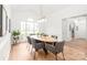 Bright dining room with hardwood floors, neutral walls, modern light fixture, and an adjacent doorway at 502 Roxanne Nw Ct, Concord, NC 28027