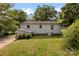 Quaint backyard with grassy lawn, mature trees, and the exterior of the light-colored home at 505 Franklin Ave, Shelby, NC 28150