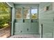 Cozy sunroom has green walls, multiple windows, and access to the outdoors at 505 Franklin Ave, Shelby, NC 28150