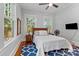 Cozy bedroom with natural light, a bed, and an accent rug on the hardwood floor at 506 Clement Ave, Charlotte, NC 28204