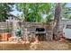This outdoor kitchen area includes a grill, Big Green Egg, prep space, and a stylish stone surround for entertaining at 506 Clement Ave, Charlotte, NC 28204