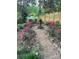 Beautiful yard with gravel pathway, fountain feature, garden beds with flowering plants, and wood fence at 506 Clement Ave, Charlotte, NC 28204