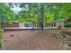 Backyard patio featuring French doors leading into the house, mature landscaping and plants and a beautiful shade tree at 514 Wood St, Troy, NC 27371