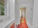 Hallway leading to a bathroom with white tiled walls and vintage fixtures at 514 Wood St, Troy, NC 27371