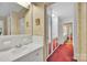Hallway leading to a bathroom with white tile and vanity at 514 Wood St, Troy, NC 27371