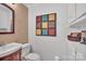 Bathroom featuring vanity with sink, toilet, brick accent wall with colorful square design and linen closet at 514 Wood St, Troy, NC 27371
