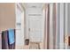 Bathroom featuring neutral tile, vanity, toilet and linen closet next to a door to the outside of the house at 514 Wood St, Troy, NC 27371