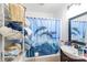 Functional bathroom with a shower-tub combo, tidy storage and bright dolphin-themed curtain at 515 Myrtle Ave, Chester, SC 29706