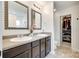 Bathroom featuring double sinks, granite countertops, and dark wood cabinetry, plus a walk-in closet at 5228 Tomsie Efird Ln, Charlotte, NC 28269