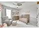 Neutral colored Bedroom featuring a crib, dresser, shelves, and a comfortable glider chair at 5228 Tomsie Efird Ln, Charlotte, NC 28269