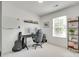 Bright, minimalist home office space with a desk, guitar, shelving, and a large window at 5228 Tomsie Efird Ln, Charlotte, NC 28269