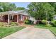 A brick home with a driveway and well-maintained landscaping and covered patio at 536 Carroll St, Statesville, NC 28625