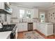 Sunlit kitchen featuring white cabinets, stainless steel appliances, hardwood floors, and charming decor for a welcoming feel at 536 Carroll St, Statesville, NC 28625