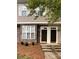 A view of the front doors of a two story tan townhouse with a rock facade on one side at 571 Goldstaff Ln, Charlotte, NC 28273