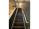 Stairway with modern gray wood treads, gray walls, and white risers and handrail at 571 Goldstaff Ln, Charlotte, NC 28273