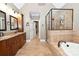 Luxurious bathroom featuring dual vanities, a soaking tub, a glass-enclosed shower, and tile flooring at 6302 Dwayne Starnes Dr, Hickory, NC 28602