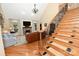 Bright living room with stone fireplace, hardwood floors, elegant furnishings, and staircase access at 6302 Dwayne Starnes Dr, Hickory, NC 28602