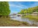 Scenic lake view highlighting a boat dock and lift, serene water, and lush green trees at 669 Kenway Loop, Mooresville, NC 28117