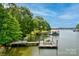 Serene lake view showcasing a boat dock with lifts, lush trees and calm water at 669 Kenway Loop, Mooresville, NC 28117
