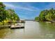 Picturesque waterfront view of a lake with boat docks, lush trees and clear blue sky at 669 Kenway Loop, Mooresville, NC 28117