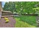 Expansive backyard featuring lush green grass, mature trees, a patio, and a screened in porch at 6938 Wrentree Dr, Charlotte, NC 28210