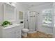 Well-lit bathroom with vanity, corner shower, white trim, and neutral vinyl flooring at 6938 Wrentree Dr, Charlotte, NC 28210
