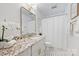 Modern bathroom featuring a vanity with granite countertop, gold fixtures, and black and white tiled floor at 6938 Wrentree Dr, Charlotte, NC 28210