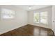 Empty room with hardwood floors, two windows and white walls, ready for personalization at 6938 Wrentree Dr, Charlotte, NC 28210