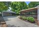 View of a driveway leading to a covered parking area and screened in porch at 6938 Wrentree Dr, Charlotte, NC 28210