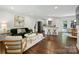 Open-concept living space with hardwood floors, stylish decor, and seamless flow to kitchen and dining area at 6938 Wrentree Dr, Charlotte, NC 28210