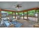 Relaxing screened porch featuring wicker furniture and a ceiling fan, perfect for outdoor lounging at 6938 Wrentree Dr, Charlotte, NC 28210