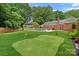 Spacious backyard featuring a pool and custom putting green at 6946 Woodstock Dr, Charlotte, NC 28210
