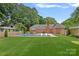 Large backyard with swimming pool, outdoor seating, and artificial grass at 6946 Woodstock Dr, Charlotte, NC 28210