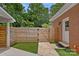 Cozy outdoor entryway featuring a modern wood fence and brick home at 6946 Woodstock Dr, Charlotte, NC 28210
