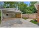 View of the carport with concrete floor, white siding, and wooden privacy fence at 6946 Woodstock Dr, Charlotte, NC 28210