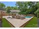 Backyard with a pool, travertine patio, and outdoor seating area at 6946 Woodstock Dr, Charlotte, NC 28210