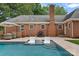Inground pool with lounge chairs and travertine patio at 6946 Woodstock Dr, Charlotte, NC 28210