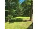 Serene backyard featuring mature trees, green lawn, and natural surroundings at 695 Knollcrest Ne Dr, Concord, NC 28025