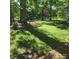 Lush backyard featuring mature trees, a green lawn and natural landscaping at 695 Knollcrest Ne Dr, Concord, NC 28025