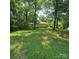 Green backyard with mature trees providing shade and privacy at 695 Knollcrest Ne Dr, Concord, NC 28025