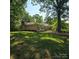 Spacious single-story home with brick exterior, chimney, mature trees, and well-manicured lawn at 695 Knollcrest Ne Dr, Concord, NC 28025