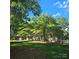Charming brick home featuring mature trees, black shutters, and a lush front yard at 695 Knollcrest Ne Dr, Concord, NC 28025
